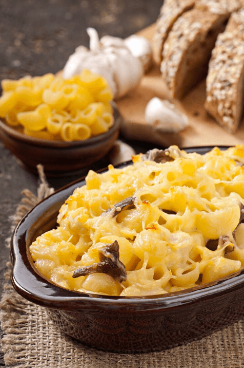 A golden, creamy bowl of 3 cheese mac and cheese topped with crispy breadcrumbs.