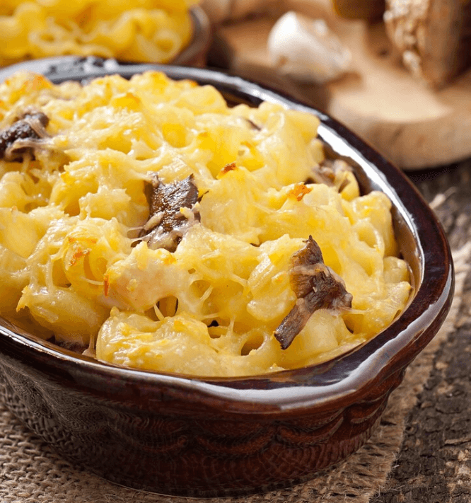 A golden, creamy bowl of 3 cheese mac and cheese topped with crispy breadcrumbs.