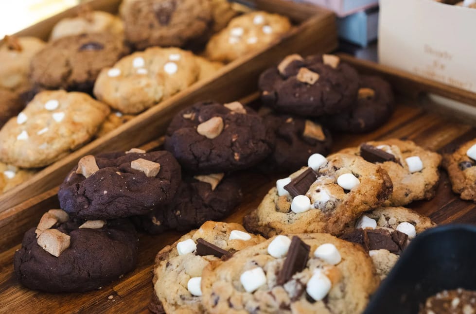 Conveyor belt producing chocolate chip cookies in a factory.