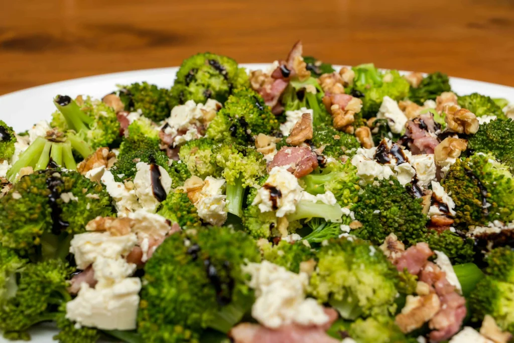 A vibrant bowl of broccoli salad from Chicken Salad Chick, showcasing fresh ingredients like broccoli, bacon, and cheese.