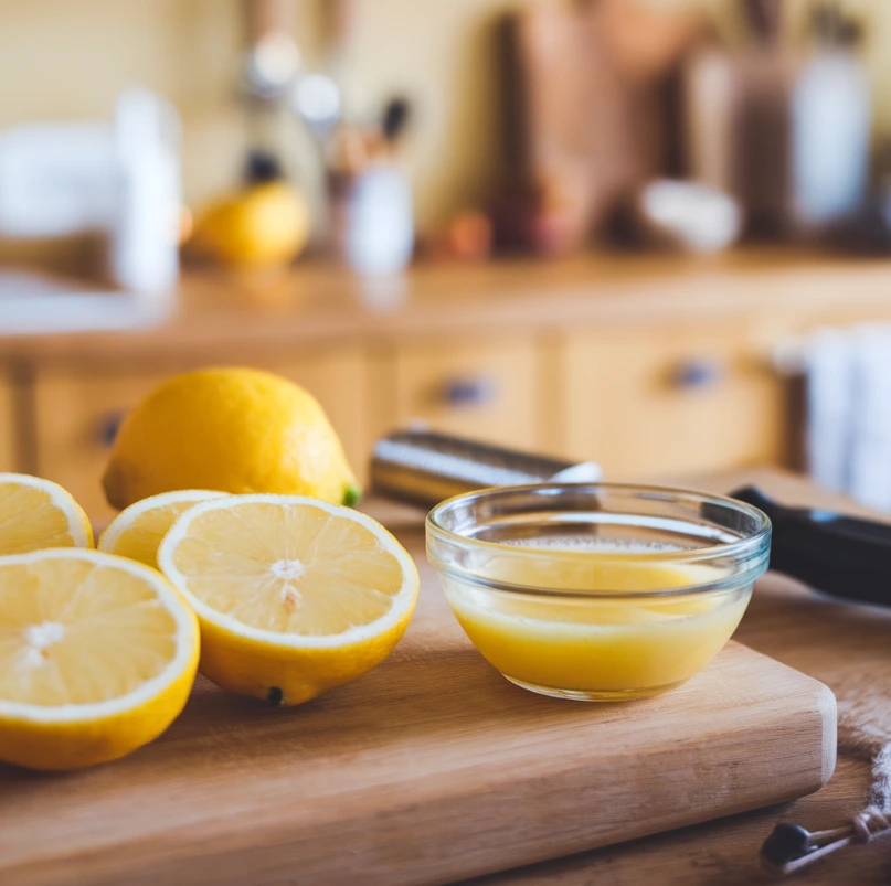 Lemon slices and freshly squeezed juice with kitchen utensils.