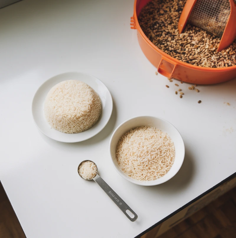 A bowl of rice mixed with vegetables on a rustic kitchen table.