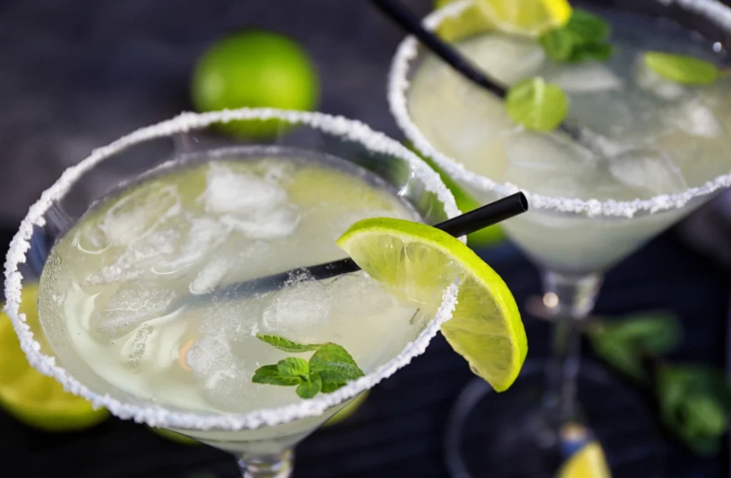 A refreshing skinny margarita garnished with lime on a summer table.